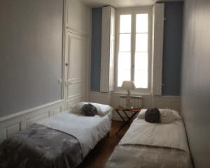 twee bedden in een kamer met een raam bij Pat & Co in Beaune