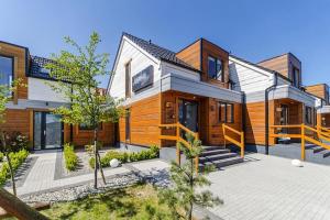 a home with wooden buildings and a courtyard at Comfortable holiday homes close to the beach in Grzybowo
