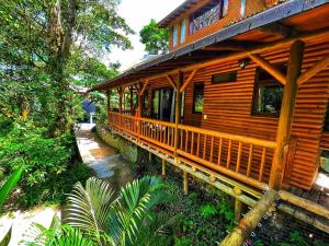 a log cabin with a porch in the woods at La Nube Eco-Hotel in Villavicencio