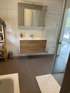 y baño con lavabo, espejo y bañera. en Lux Apartmant 2 Westerstede, en Westerstede