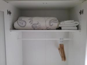 un estante blanco con toallas y toallas. en Studios Greenside, en Coímbra