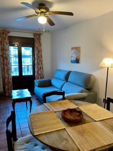 Apartamentos Turismo Rural Casa Alfós في لابويردا: غرفة معيشة مع أريكة زرقاء وطاولة