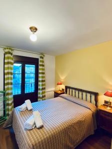 1 dormitorio con 1 cama con 2 toallas en Apartamentos Turismo Rural Casa Alfós, en Labuerda