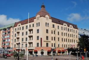 un gran edificio blanco con techo marrón en Home Hotel Drott, en Karlstad