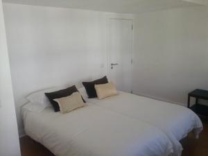 białe łóżko z dwoma poduszkami w obiekcie Studios Greenside w mieście Coimbra