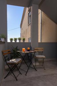 un tavolo e 2 sedie seduti su un balcone di Batinic Apartments a Kaštela (Castelli)