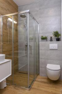 a shower stall in a bathroom with a toilet at Batinic Apartments in Kaštela