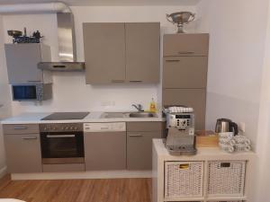 a small kitchen with white cabinets and a sink at Grenzberg Appartements in Bad Gastein