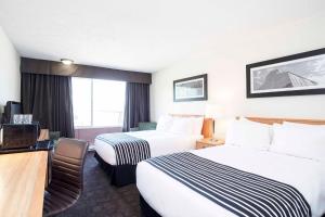 a hotel room with two beds and a desk at Sandman Inn McBride in McBride