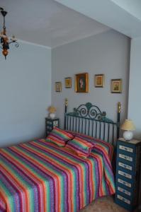 1 dormitorio con 1 cama con una manta a rayas de colores en Casa el Castell en Eslida