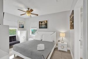 una camera da letto bianca con un letto e un ventilatore a soffitto di Ocean Breeze Villa a Pompano Beach Altre 42 foto
