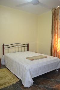 1 dormitorio con 1 cama con edredón blanco en Apartment is calm locality, en Flic en Flac