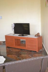 a flat screen tv sitting on top of a wooden cabinet at Apartment is calm locality in Flic-en-Flac