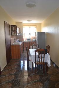a kitchen with a table and chairs and a kitchen with a sink at Apartment is calm locality in Flic-en-Flac