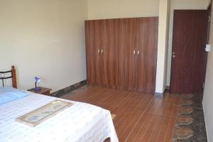 a bedroom with a bed and a wooden cabinet at Apartment is calm locality in Flic-en-Flac