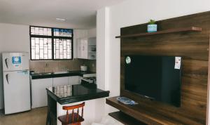a kitchen with a large television and a refrigerator at Villa del Mar Departamentos in Salinas