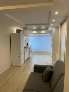 a living room with a couch and a refrigerator at APARTAMENTOS SAN JUAN de GAZTELUGATXE in Bermeo