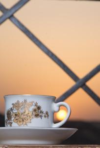 a coffee cup sitting on a plate on a table at ASWAN NILE PALACE (swimming pool-rooftop-Nile view) in Aswan