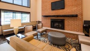 a living room with a fireplace and a tv at Best Western Plus Newark/Christiana Inn in Bear