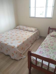 瓜拉派瑞Casa em Guarapari, próximo a praia do morro的一间卧室，配有两张床和一扇窗户