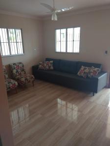 a living room with a blue couch and two chairs at Casa em Guarapari, próximo a praia do morro in Guarapari