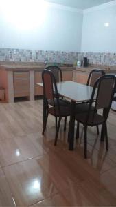 una mesa y 4 sillas en una cocina en Casa em Guarapari, próximo a praia do morro, en Guarapari