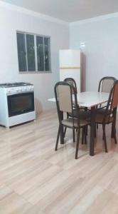 uma cozinha com uma mesa, cadeiras e um fogão em Casa em Guarapari, próximo a praia do morro em Guarapari