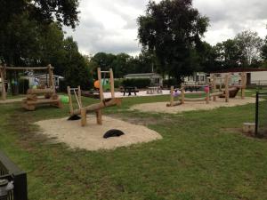 a playground with a bunch of play equipment in a park at Detached chalet on a holiday park with two terraces, near Alkmaar in Hensbroek