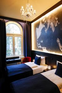 a hotel room with two beds and a chandelier at Sleephotels Casino in Hamburg
