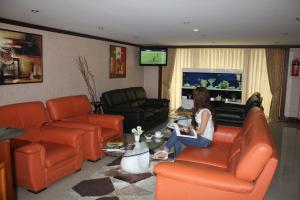 a woman sitting in a living room playing a video game at Alp Inn Hotel in Baku