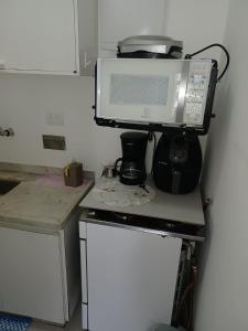 un microondas en la parte superior de un mostrador en la cocina en Ipanema VP 603 Posto 8 charmoso e aconchegante, en Río de Janeiro
