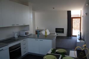 a kitchen with white cabinets and a counter top at Mallus Agroturismo in Misquel