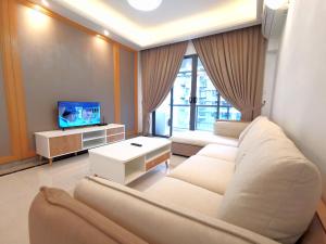 sala de estar con sofá y TV en R&F Princess Cove X Maco at Johor Bahru, en Johor Bahru