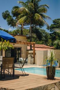a patio with a table and chairs next to a pool at Rancho Garcinha - Lago de Furnas in São José da Barra