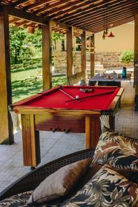 a pool table with a red cloth on top of it at Rancho Garcinha - Lago de Furnas in São José da Barra
