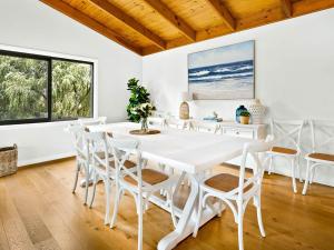 a white dining room with a white table and chairs at Sandy Feet Retreat in Cape Woolamai