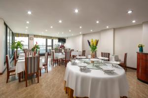 a dining room with tables and chairs and flowers at Bounty Hotel in Hanoi