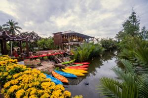 eine Gruppe Kajaks auf dem Wasser vor einem Haus in der Unterkunft Good Time Relax Resort in Kampot