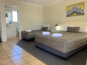 Postel nebo postele na pokoji v ubytování Biloela Palms Motor Inn