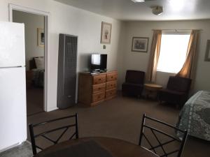 a living room with a television and a dresser at Bishop Village Motel in Bishop