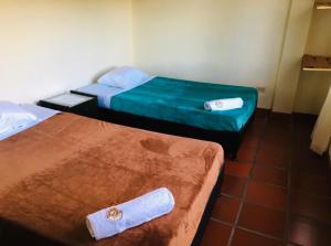 two twin beds in a room with at MALAVI Cabaña Nobsa in Nobsa