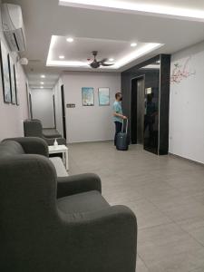 una persona parada en una sala de espera con una maleta en MORNINGS HOTEL, en Sungai Petani
