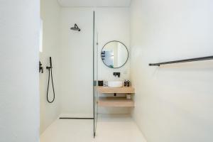 a bathroom with a shower and a mirror at Droom Guesthouse in Franschhoek