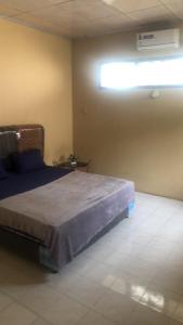 1 dormitorio con 1 cama en una habitación con ventana en Penginapan al fatih, en Kampungdurian