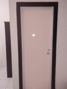 uma porta branca com uma moldura preta num quarto em Penginapan al fatih em Kampungdurian