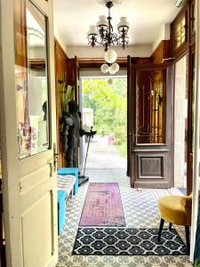 a hallway with a door and a chandelier at Demoiselle des Roches in Ramonchamp