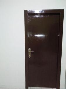 uma porta castanha com uma maçaneta de metal num quarto em Penginapan al fatih em Kampungdurian
