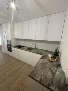 cocina con armarios blancos y encimera en V&G Apartment en Leópolis