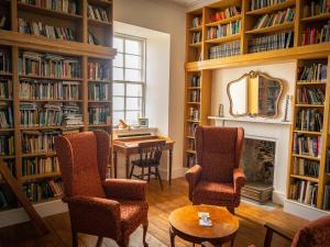 a library with a table and chairs and a fireplace at Freswick Castle in Wick