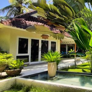 a house with a pool in front of it at The Forty Eight Resort Candidasa in Candidasa